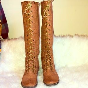 Brown lace up boots that has a zipper on the side